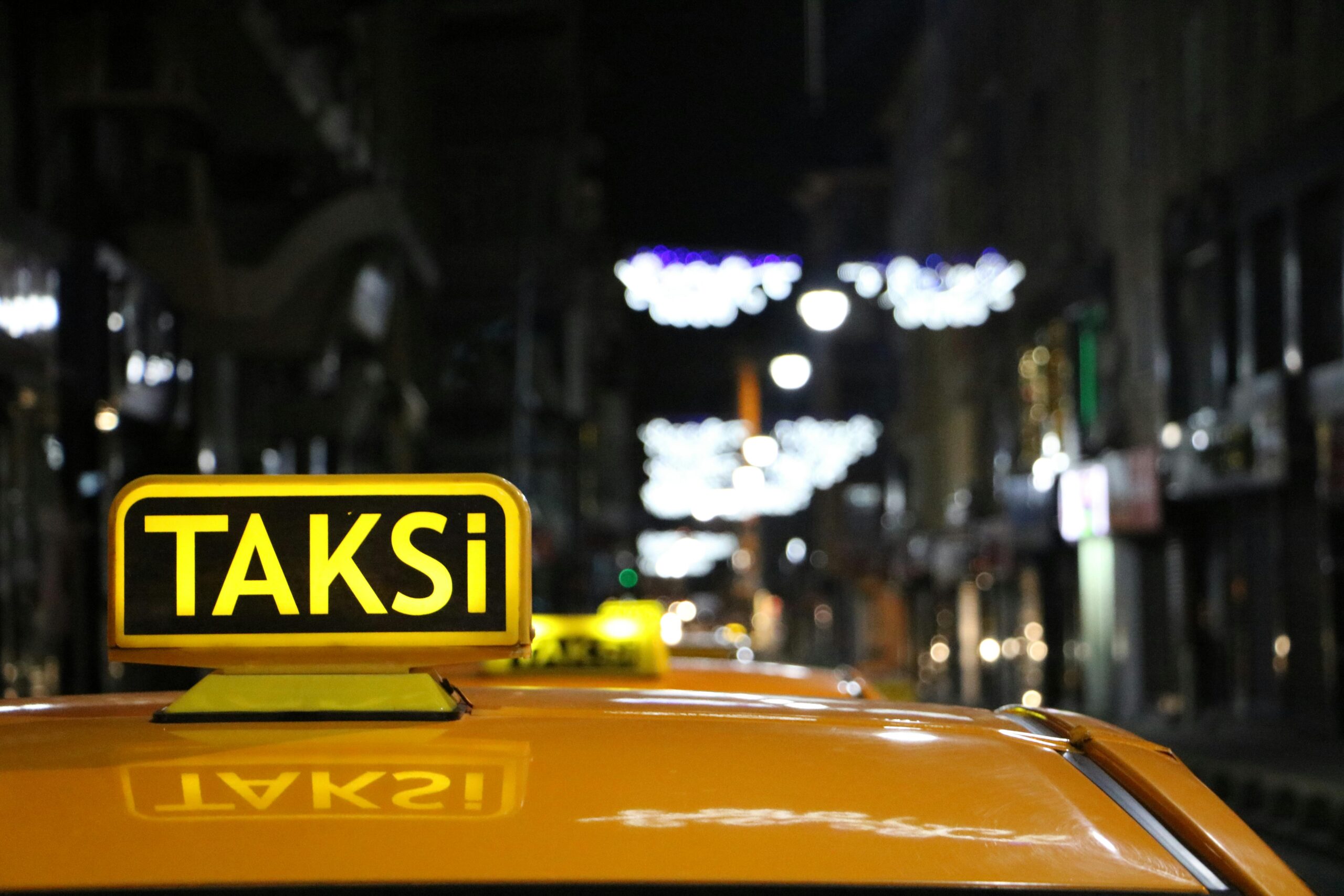Urban night scene featuring a taxi with glowing lights on a bustling street.